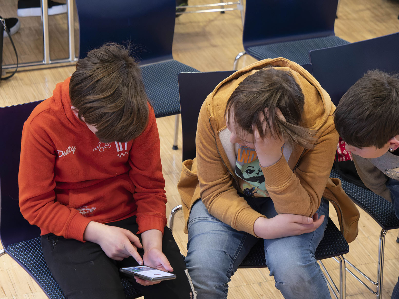 Zwei Jugendliche sind mit ihrem Handy beschäftigt. Eröffungsfeier des Jugenraumes Rietz