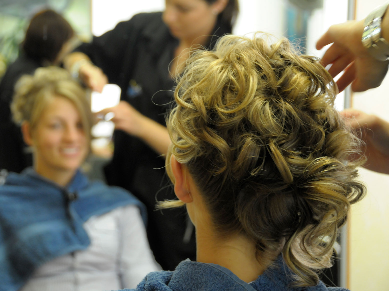 Der Braut wird beim Friseur die Haare gesteckt