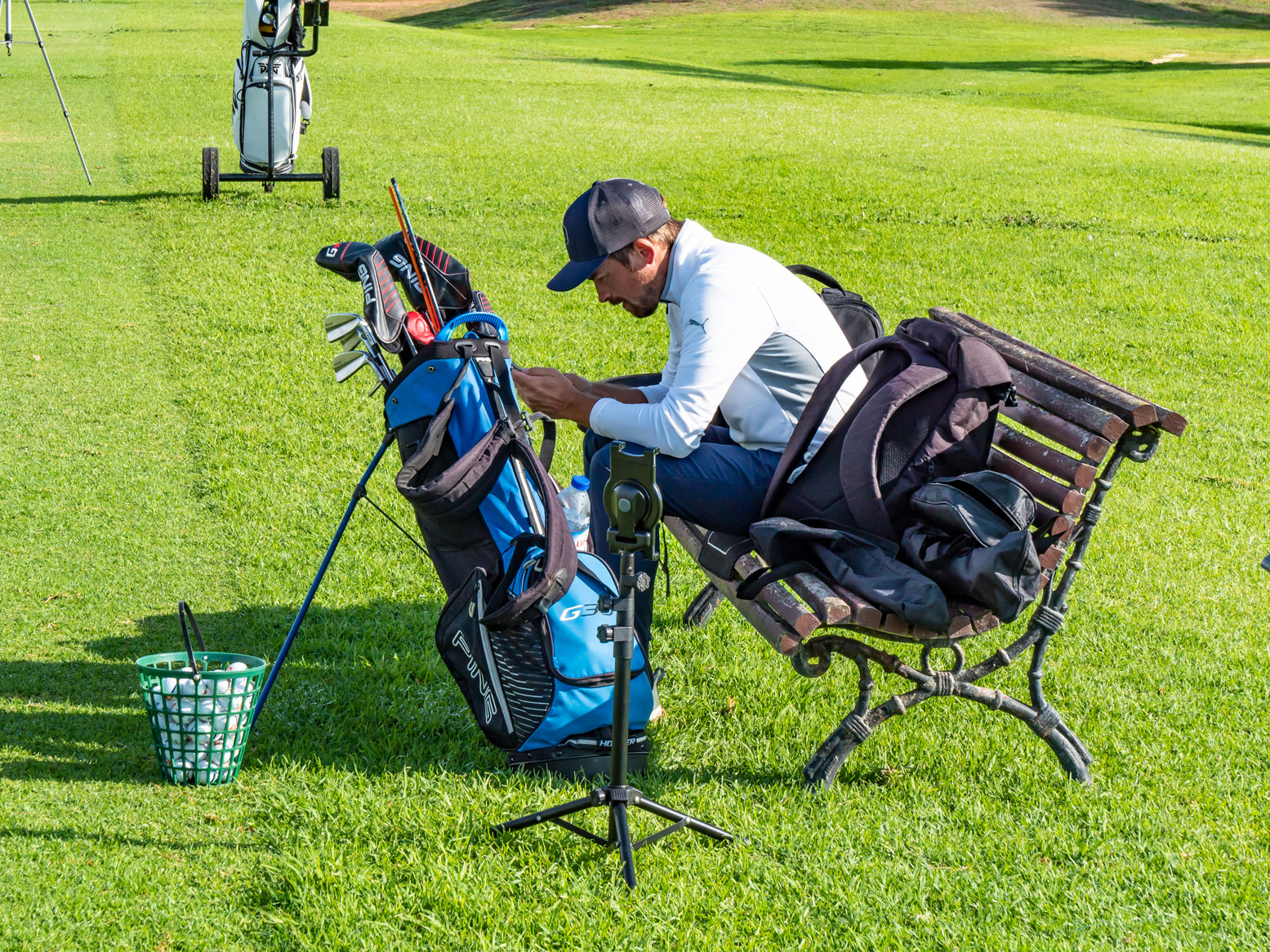 Golfpro ist mit dem Smartphone beschäftigt